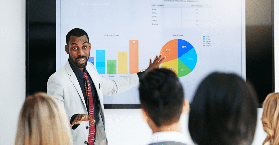 Man presents market trends to sales team