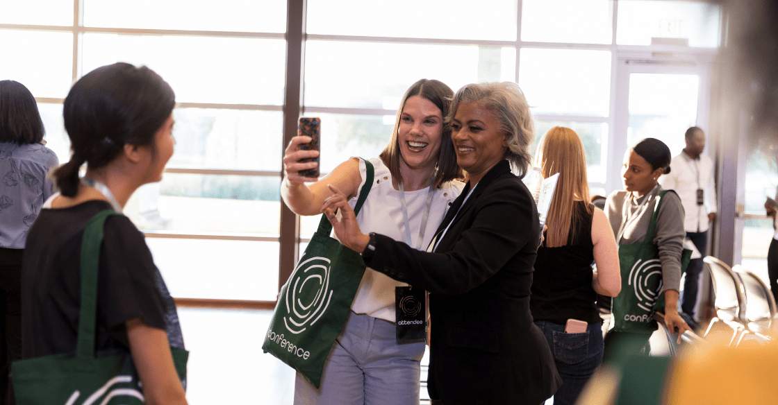 Women take a photo together at a conference